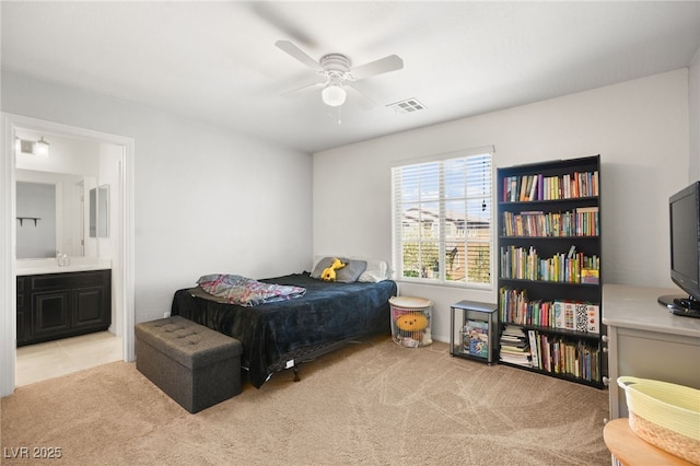 carpeted bedroom featuring a ceiling fan, visible vents, ensuite bathroom, and a sink