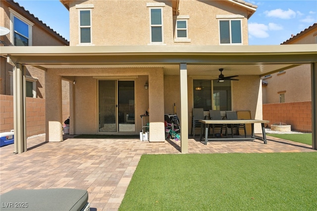 back of house with stucco siding, ceiling fan, a patio, and fence