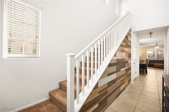 stairway with tile patterned flooring, baseboards, and ceiling fan