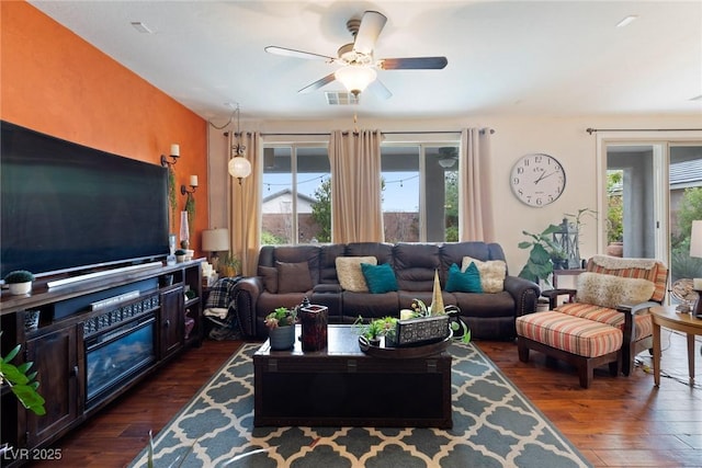 living room with ceiling fan and dark wood-type flooring