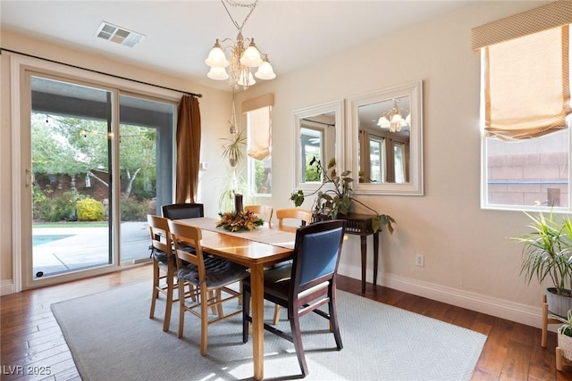 dining room featuring wood-type flooring and an inviting chandelier