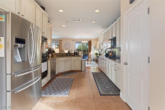 kitchen featuring cream cabinets, black appliances, sink, light tile patterned floors, and kitchen peninsula