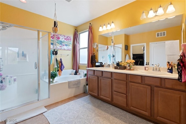 bathroom with vanity and shower with separate bathtub