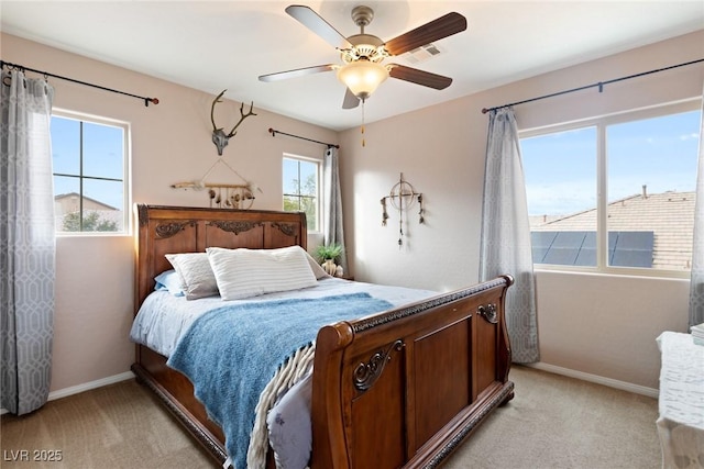 carpeted bedroom with ceiling fan and multiple windows