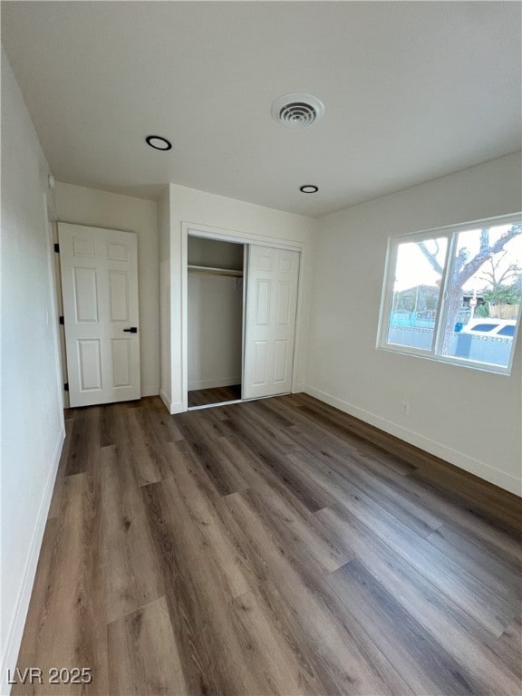 unfurnished bedroom with wood-type flooring and a closet