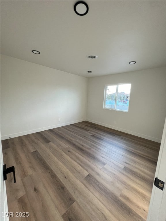 unfurnished room with wood-type flooring