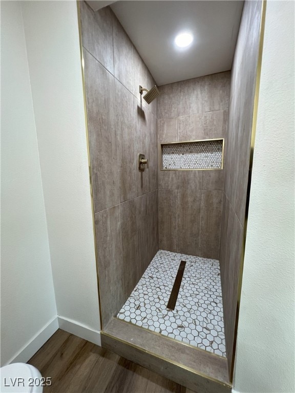 bathroom featuring hardwood / wood-style floors and a tile shower