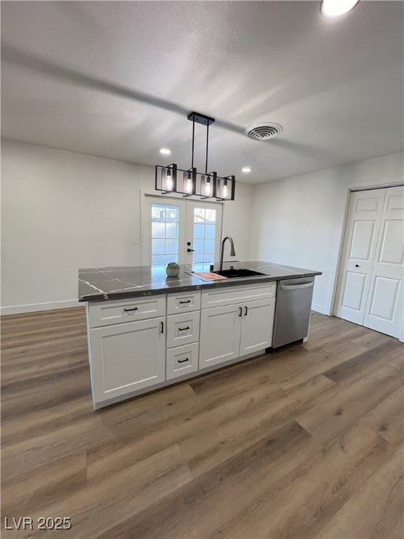 kitchen with white cabinetry, dishwasher, sink, hanging light fixtures, and wood-type flooring