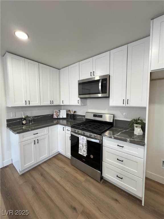 kitchen with white cabinetry, dark wood-type flooring, and appliances with stainless steel finishes