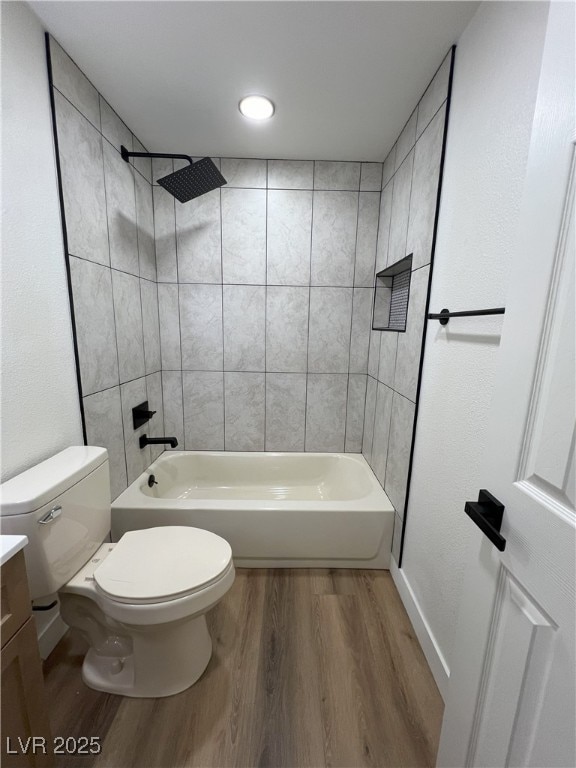 full bathroom with vanity, hardwood / wood-style flooring, toilet, and tiled shower / bath