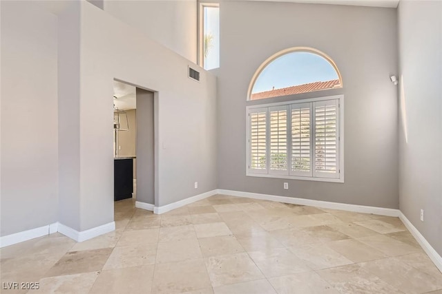 spare room featuring a towering ceiling