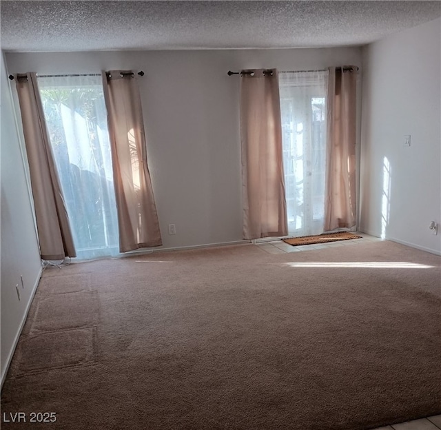 carpeted empty room featuring a textured ceiling