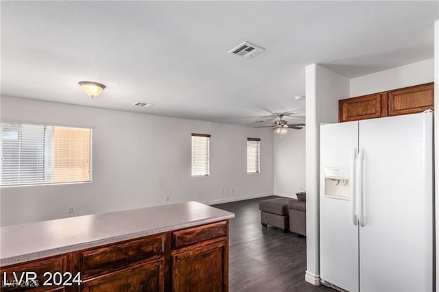 kitchen with dark hardwood / wood-style flooring, white fridge with ice dispenser, and ceiling fan