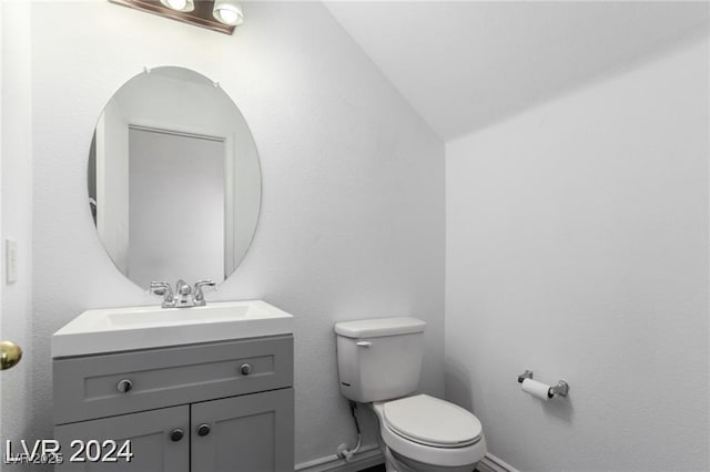 bathroom with vanity, toilet, and vaulted ceiling