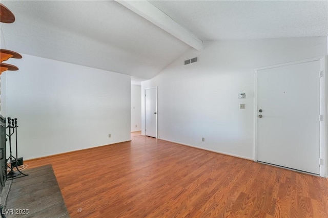 unfurnished living room with hardwood / wood-style floors, beam ceiling, and high vaulted ceiling