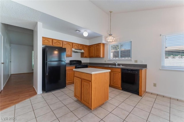 kitchen featuring pendant lighting, a center island, light tile patterned floors, and black appliances