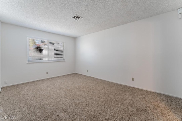 carpeted empty room featuring a textured ceiling