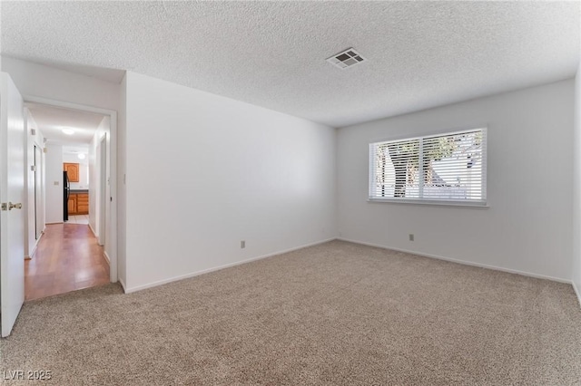 unfurnished room with carpet floors and a textured ceiling