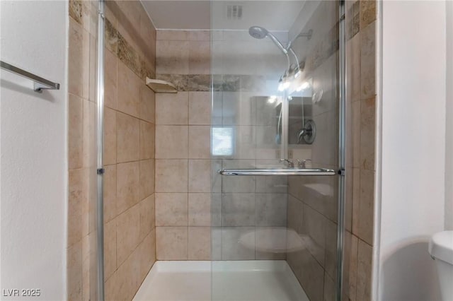 bathroom with toilet and an enclosed shower