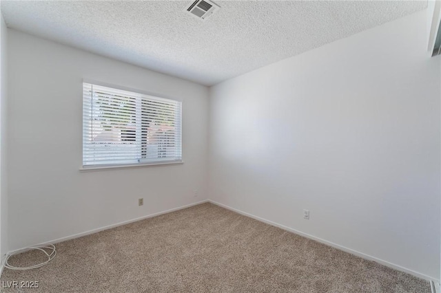 carpeted spare room with a textured ceiling