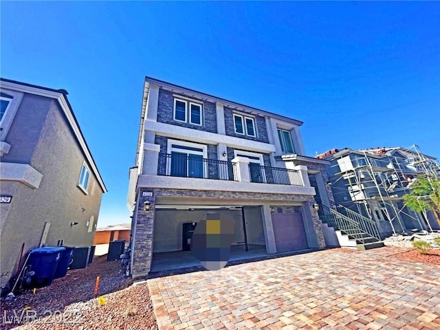 view of front of property featuring a balcony and a garage