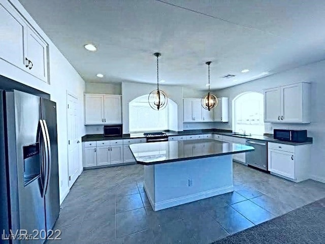 kitchen featuring pendant lighting, white cabinets, stainless steel appliances, and a kitchen island