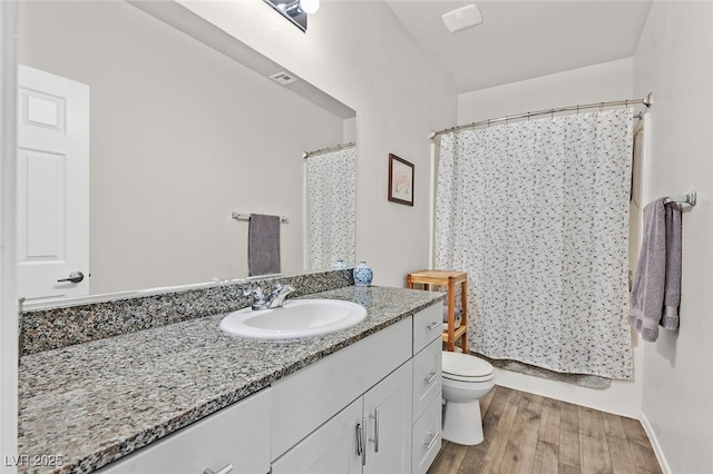 full bathroom featuring vanity, hardwood / wood-style flooring, toilet, and shower / tub combo with curtain