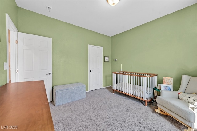 carpeted bedroom featuring a crib