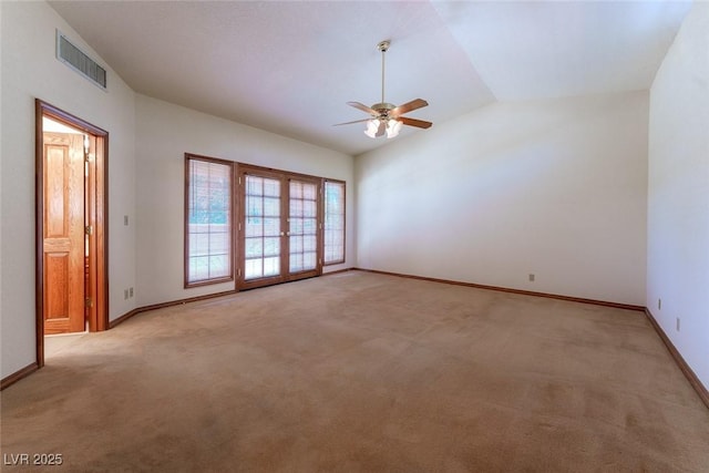 spare room with light carpet, lofted ceiling, visible vents, and baseboards