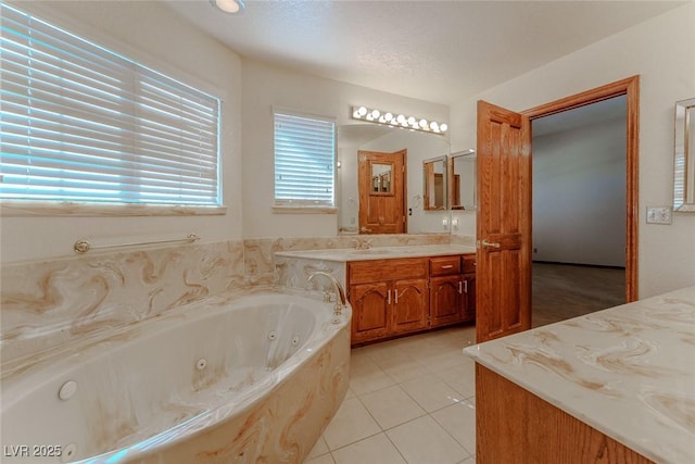 bathroom featuring a whirlpool tub, vanity, and tile patterned floors