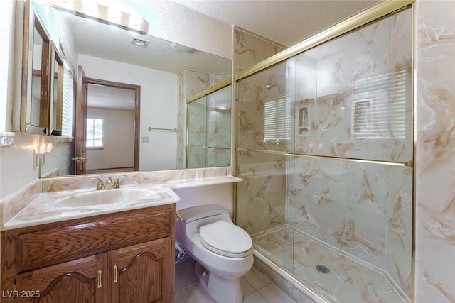 full bath featuring toilet, tile patterned flooring, a marble finish shower, and vanity