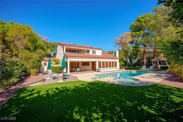 back of property with an outdoor pool, a patio area, a yard, and an in ground hot tub