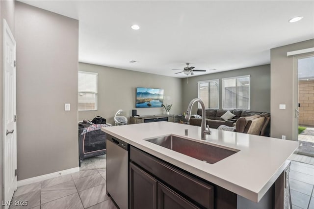 kitchen with dishwasher, a center island with sink, sink, ceiling fan, and dark brown cabinets