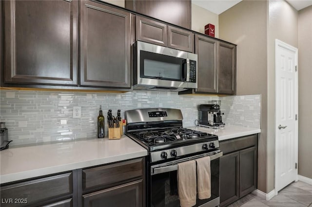 kitchen featuring decorative backsplash, appliances with stainless steel finishes, dark brown cabinetry, and light tile patterned flooring