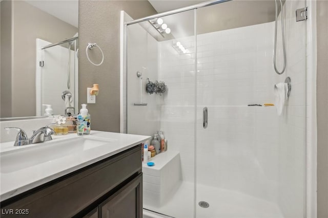 bathroom featuring vanity and a shower with door