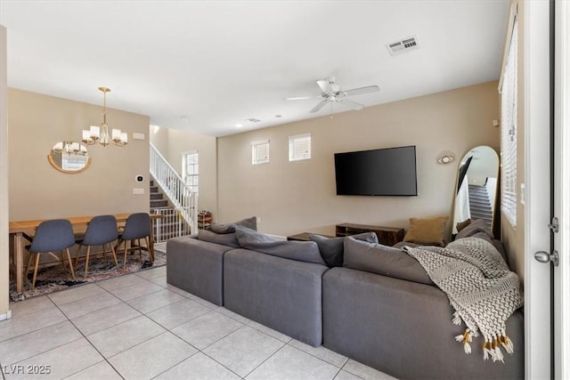 living room featuring light tile patterned flooring and ceiling fan with notable chandelier