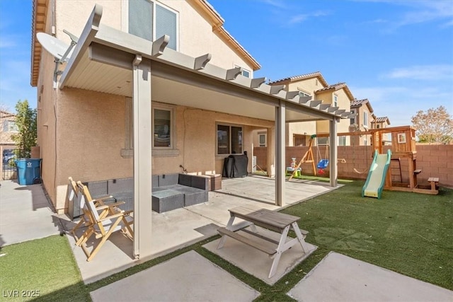 rear view of property featuring a playground and a patio area