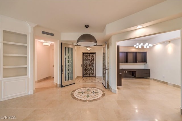 hall featuring built in features, light tile patterned flooring, and a notable chandelier