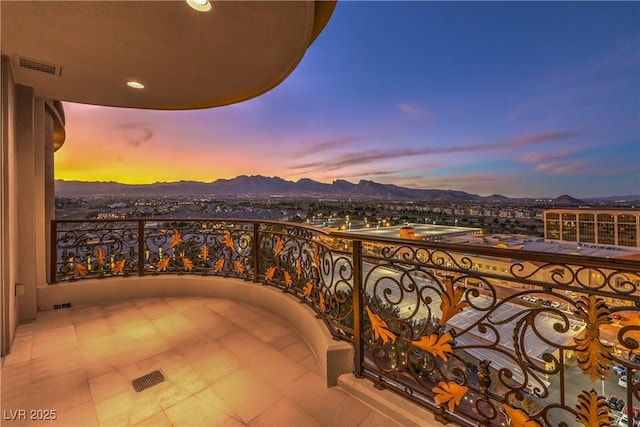 balcony at dusk featuring a mountain view