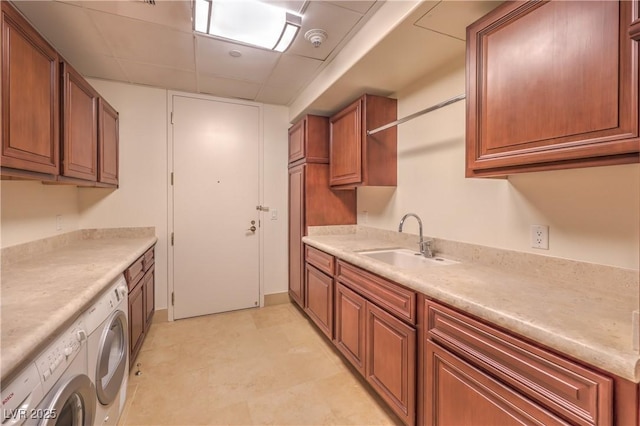 kitchen with a drop ceiling, sink, and washing machine and clothes dryer