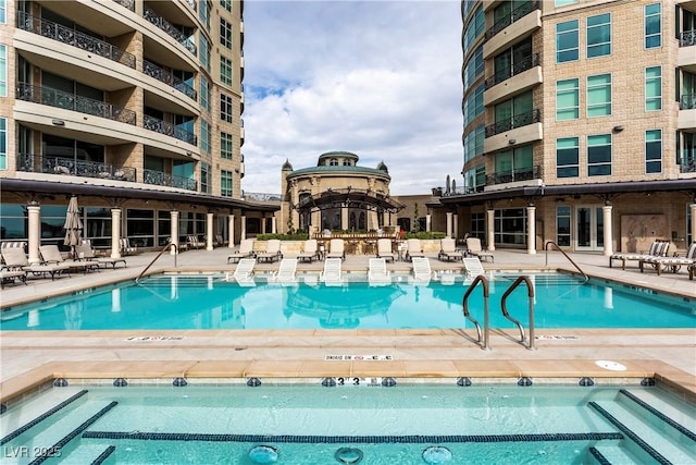 view of swimming pool featuring a community hot tub and a patio