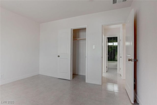 unfurnished bedroom featuring light tile patterned flooring and a closet