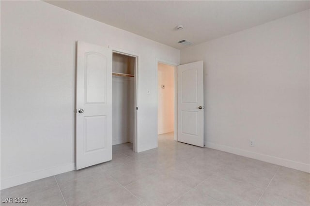 unfurnished bedroom featuring light tile patterned flooring and a closet