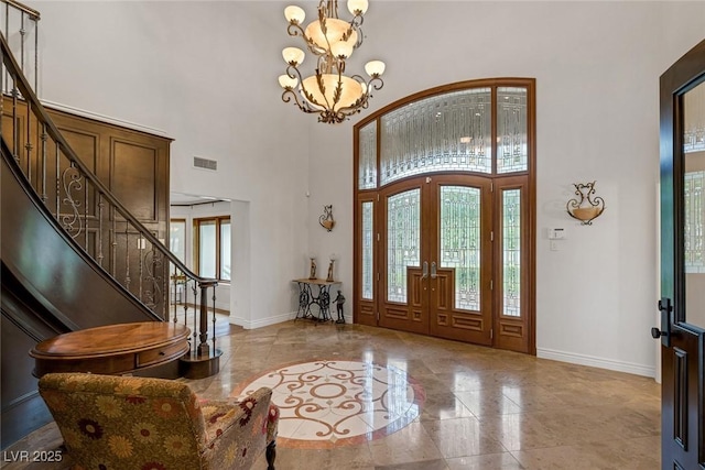 foyer featuring a notable chandelier, a high ceiling, and french doors