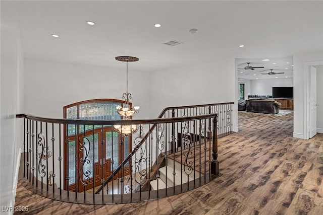 hallway featuring a notable chandelier and wood-type flooring