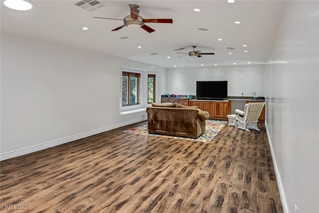 living room with ceiling fan and dark wood-type flooring