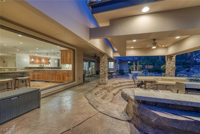 view of patio / terrace with ceiling fan and an outdoor kitchen