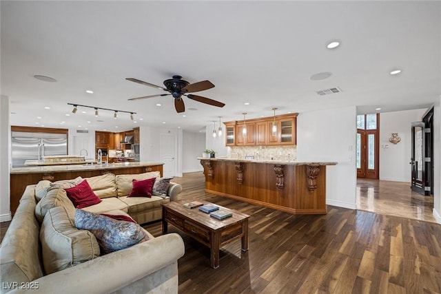 living room featuring ceiling fan and dark hardwood / wood-style flooring