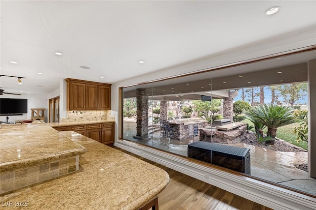 kitchen with decorative backsplash, a wealth of natural light, and light hardwood / wood-style flooring