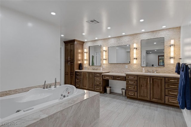 bathroom featuring tiled tub, tile patterned flooring, and vanity